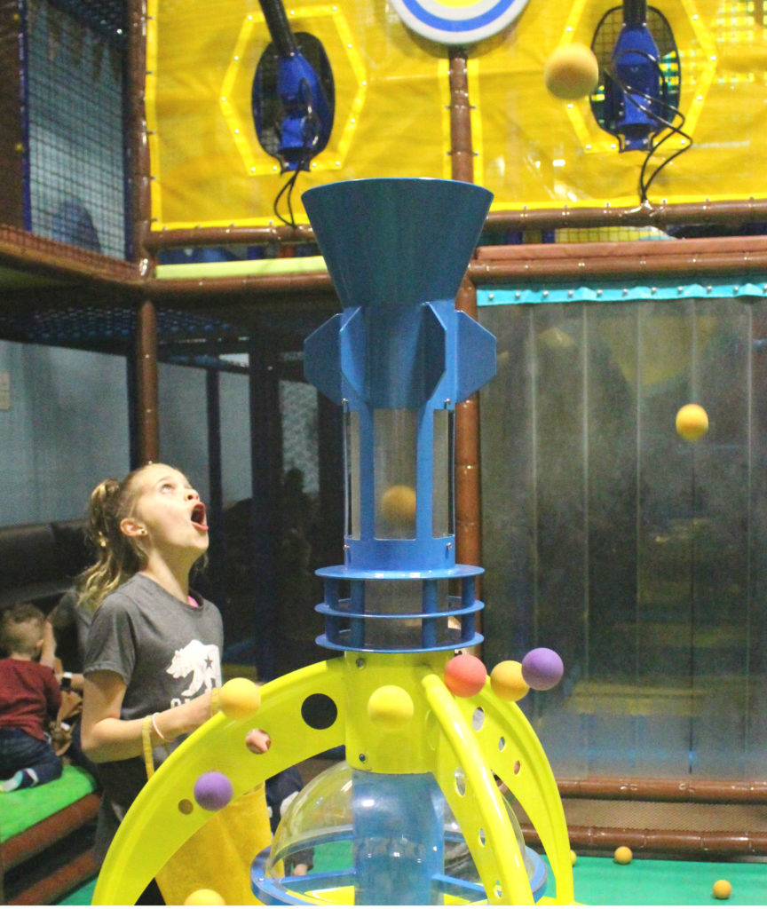 A child gasps and laughs at our ball fountain.